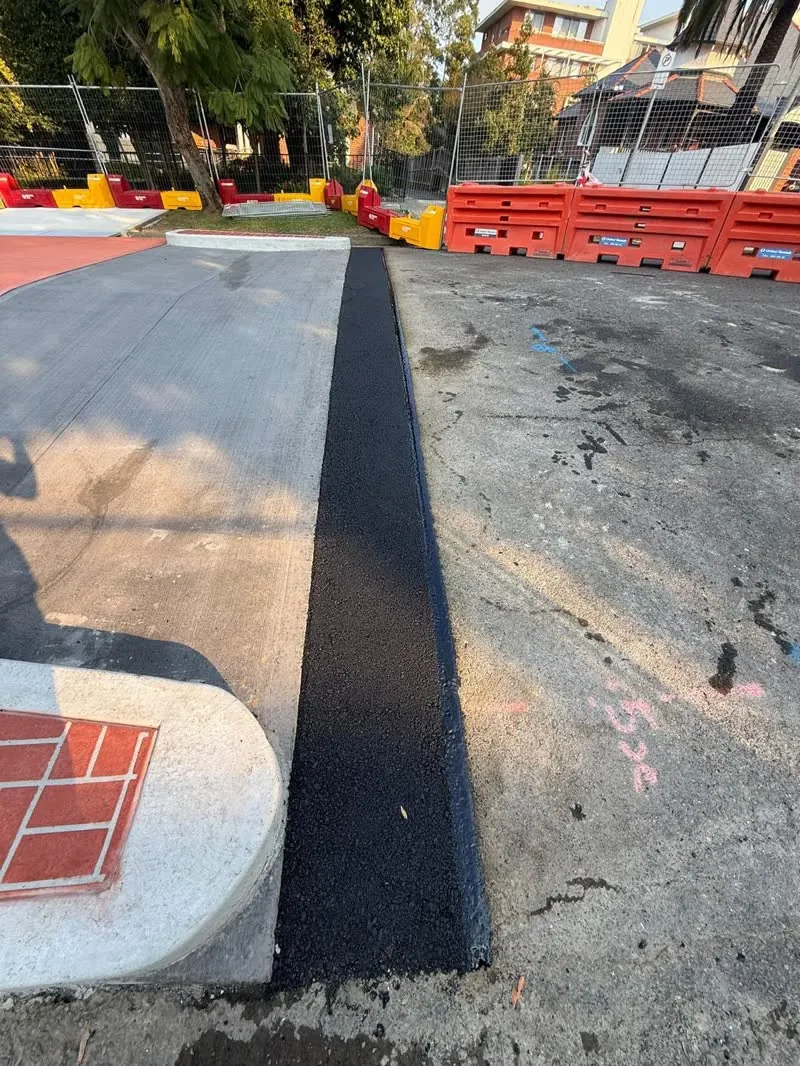 Asphalt strip laid between traffic barriers